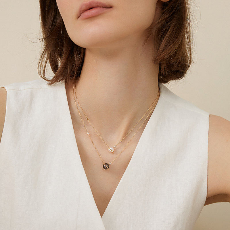 Saltwater pearl and diamond planet necklace in 18K gold from Star Trails Collection, featuring a celestial-inspired design.