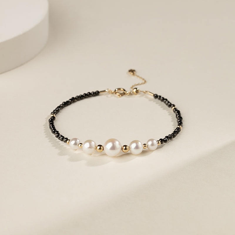 Gold vermeil freshwater pearl and black spinel beaded smile bracelet, flat lay