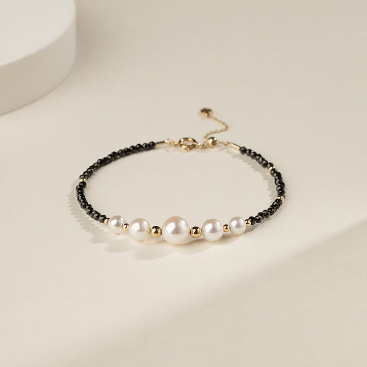 Gold vermeil freshwater pearl and black spinel beaded smile bracelet, flat lay