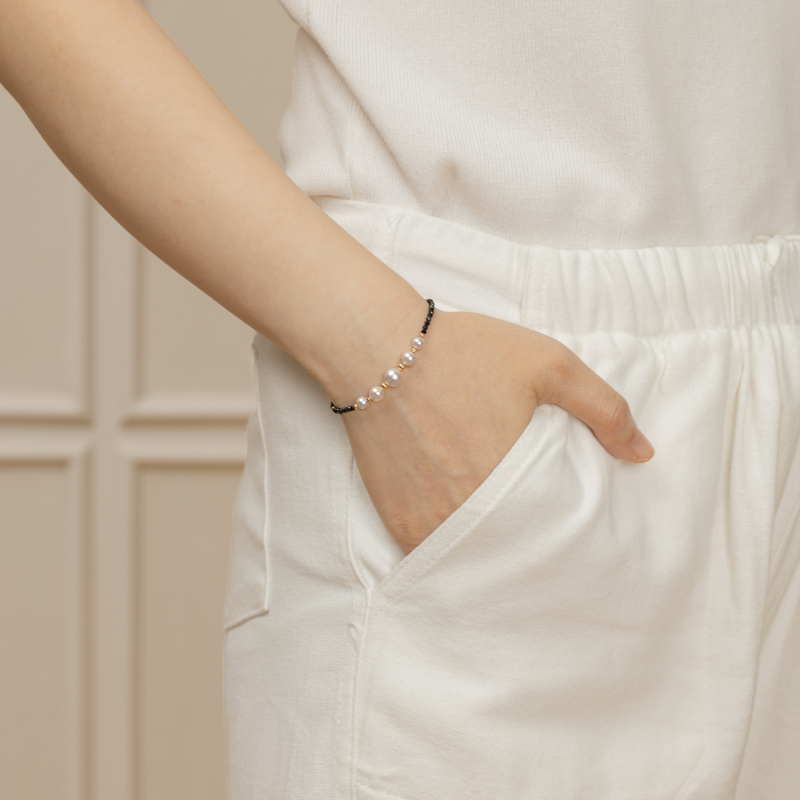 Model wearing freshwater pearl and black spinel gold vermeil bracelet, side wrist view