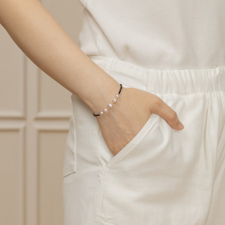 Model wearing freshwater pearl and black spinel gold vermeil bracelet, side wrist view