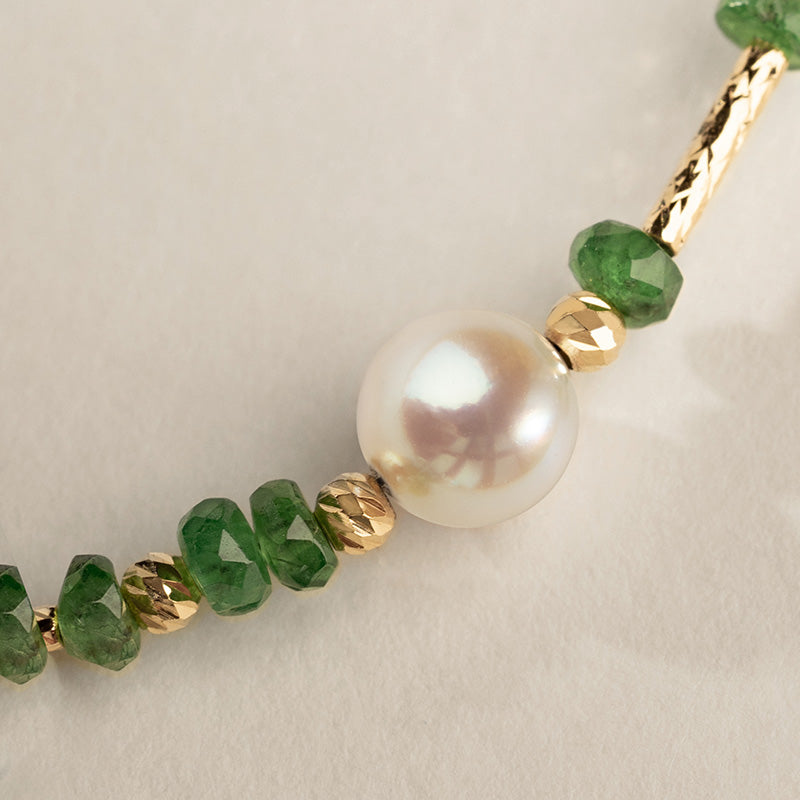 Close-up of AAAAA freshwater pearl surrounded by tsavorite beads and gold vermeil accents, bracelet detail