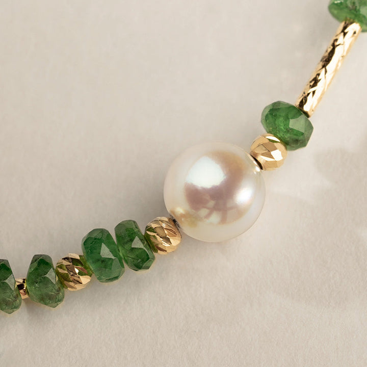 Close-up of AAAAA freshwater pearl surrounded by tsavorite beads and gold vermeil accents, bracelet detail
