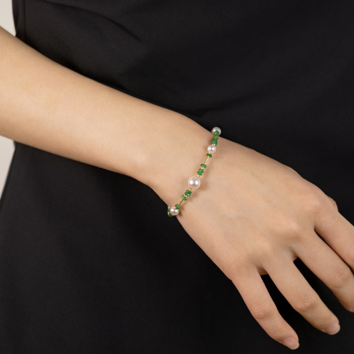 Model wearing freshwater pearl and tsavorite gold vermeil baby's breath bracelet, front wrist view