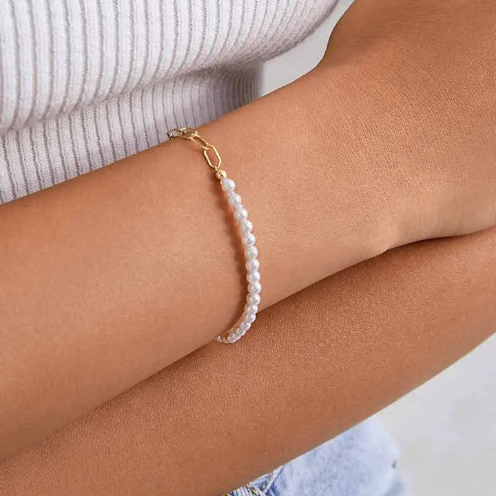Close-up of freshwater pearl and gold vermeil chain bracelet worn on wrist, side view