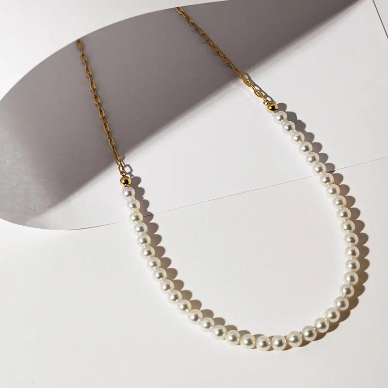 Freshwater pearl gold vermeil half chain sterling silver necklace laid flat on white surface